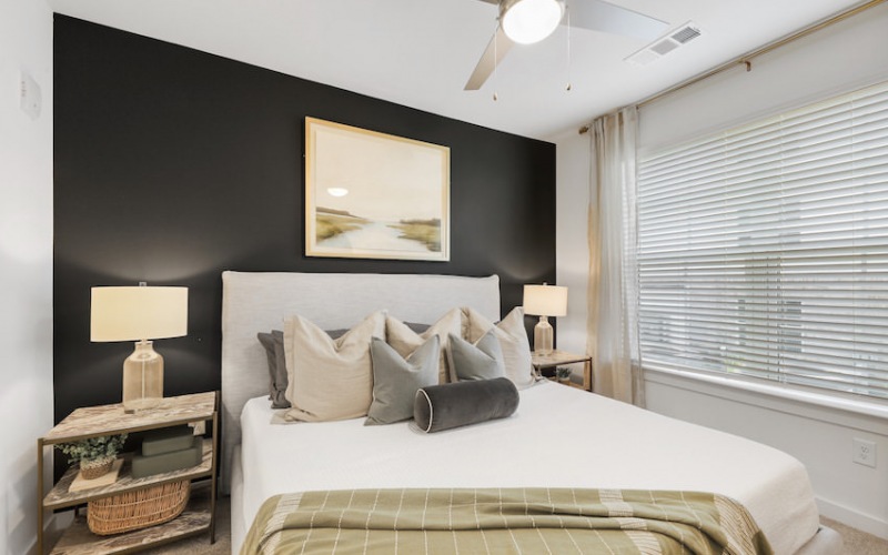 King sized bed with modern furnishings in model unit at The Finch